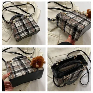 Detail showing tweed pattern texture, leather stitching, and golden hardware of the bag