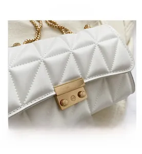 Détail du sac à bandoulière en similicuir blanc matelassé avec boucle et chaîne dorées
