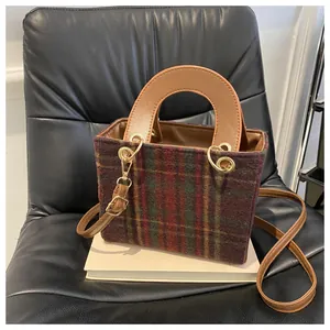 Detail of vintage houndstooth tote bag on leather chair with brown PU leather handles