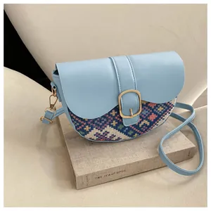 Detailed view of the ethnic weave texture and golden metal buckle on saddle bag