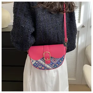Ethnic patchwork saddle bag in magenta leather and colorful embroidery on model
