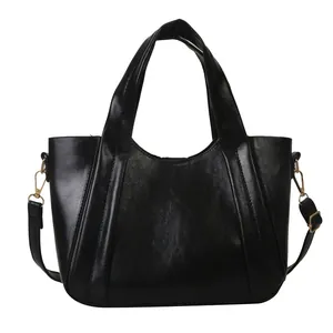 Classic black high-capacity tote bag in glossy PU leather with adjustable shoulder strap