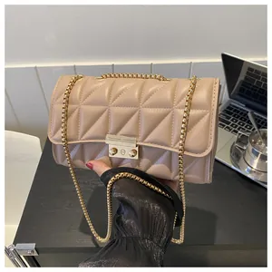 Détail du sac bandoulière matelassé beige avec fermoir doré et bandoulière en chaîne métal