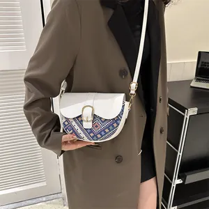 Ethnic patchwork saddle bag with white leather flap and colorful geometric fabric