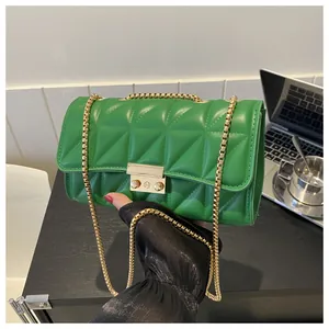 Détail d'un sac vert matelassé avec chaîne dorée et fermoir métallique rectangulaire
