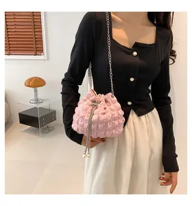 Details der rosa Plissee-Beuteltasche mit Perlenzugband und silberner Kettenriemen