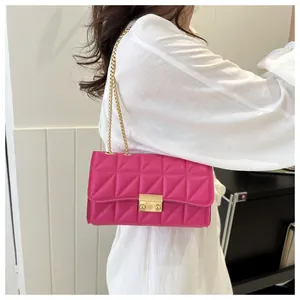 Détail du sac bandoulière matelassé rose rouge avec chaîne dorée et fermoir métal