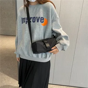 Minimalistische zwarte oxford crossbodytas met gespsluiting gedragen door een model