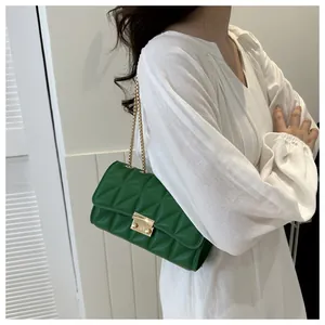 Détail du sac matelassé vert avec bandoulière en chaîne dorée et fermoir en métal