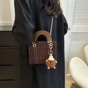 Vintage houndstooth wool handbag with leather handles and plush monster charm
