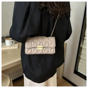 Détail du sac à bandoulière matelassé beige avec chaîne dorée et fermoir à poussoir chic