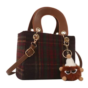 Retro houndstooth wool handbag with leather handles and a plush owl charm detail