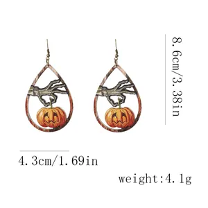 Dettaglio orecchini di Halloween in legno con mano di scheletro e motivo zucca