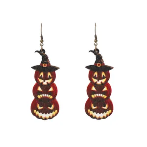 Dettaglio di orecchini di Halloween con zucche impilate e design con cappello da mago