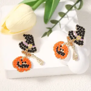 Détail de boucles d'oreilles Halloween avec chapeau de sorcière et citrouille perlé