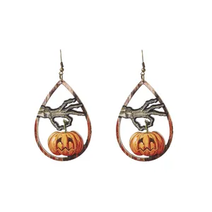 Orecchini pendenti di Halloween in legno con mano di scheletro e zucca arancione