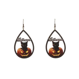 Dettaglio di orecchini di Halloween in legno con gatto nero e design a zucca