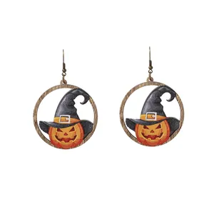 Dettaglio di orecchini in legno per Halloween con testa di zucca e cappello da mago