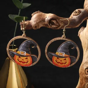 Dettaglio degli orecchini in legno di Halloween con zucca e cappello da strega