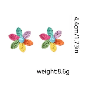 Dettaglio di orecchini a margherita in rafia fatti a mano, altezza 4,4cm e peso 8,6g