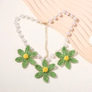 Dettaglio collana margherita fatta a mano con perle bianche e fiori intrecciati