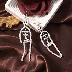 Handmade beaded skull earrings for Halloween with intricate white and black beadwork