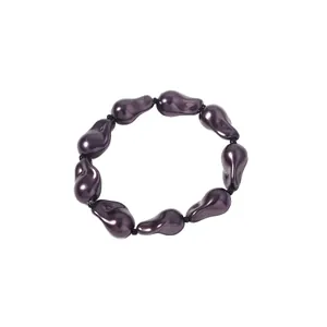 Detailansicht eines unregelmäßigen tiefvioletten Perlenarmbands mit Metallic-Glanz