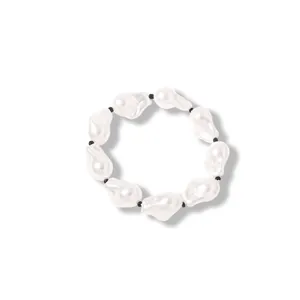Nahaufnahme von barocken Perlen mit kleinen schwarzen Zwischenperlen auf einem Armband