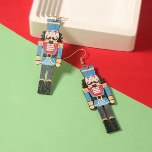 Detalle de pendientes de cascanueces de madera colorida con ganchos dorados festivos