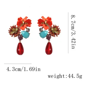 Detailed view of bohemian floral drop earrings with size markers and red teardrop gems