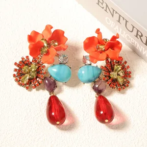 Detailed macro of vintage bohemian resin flower earrings with blue teardrop stones