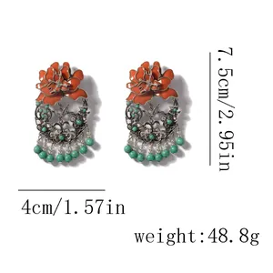 Detail van emaille bloem oorbellen met oranje blaadjes en afmetingen van 7,5cm bij 4cm
