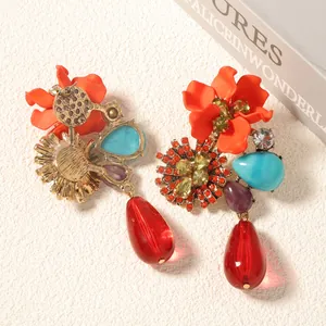 Detailed macro view of resin flower teardrop earrings with crystals and gold finish