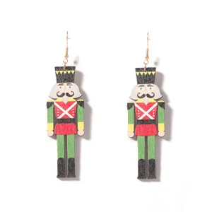 Detalle de pendientes cascanueces de madera colorida con motivos festivos y ganchos dorados