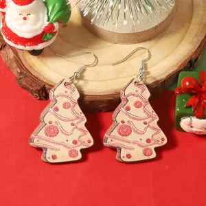 Détail de boucles d'oreilles sapin de Noël en bois avec motifs rouges sur fond festif