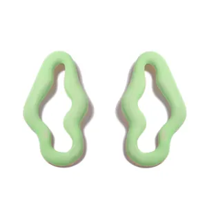Dettaglio del design cavo ondulato irregolare verde chiaro di questi eleganti orecchini