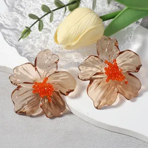 Modieuze amberkleurige acryl bloemoorsteker met oranje kralen hart voor dames