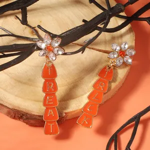 Halloween Trick or Treat orange enamel star earrings with crystal studs on wood background