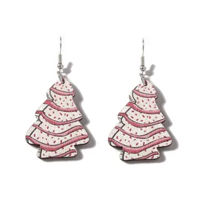 Détail macro de boucles d'oreilles sapin de Noël en bois aux motifs rouge et blanc