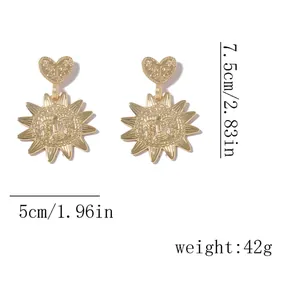 Detail shot of gold alloy sunflower and heart earrings showing 7.5cm height dimensions