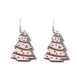 Détail macro de boucles d'oreilles sapin de Noël en bois avec rayures rouges