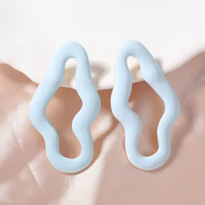 Orecchini a onde azzurro chiaro su supporto bianco con seta rosa elegante