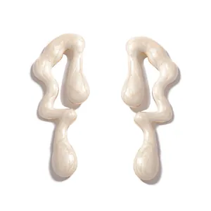 Primer plano de pendientes de onda abstracta con acabado de esmalte blanco crema