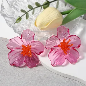 Detail van doorschijnende roze acryl bloemoorbellen met oranje kralen in het midden