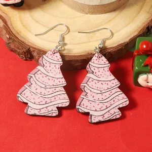 Détail de boucles d'oreilles sapin de Noël en bois peint sur un support en bois rustique