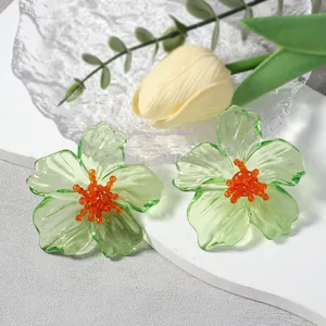 Gedetailleerd macrobeeld van groene acryl bloemoorbellen met felle oranje kralen