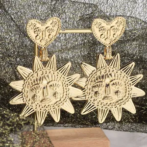 Detailed view of bohemian gold sunburst drop earrings with embossed heart design