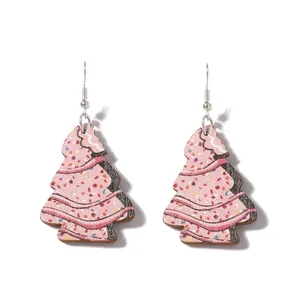 Gros plan détaillé de boucles d'oreilles sapin de Noël en bois rose avec motif biscuit