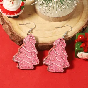 Boucles d'oreilles sapin de Noël en bois avec motifs roses sur un support en bois naturel