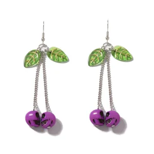 Detailed view of silver chain earrings featuring green leaves and purple skull charms